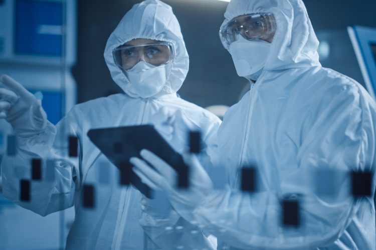 Factory Cleanroom: Engineer and Scientist Wearing Coveralls, Standing in Workshop Talk and Use Tablet Computer, Professionals Develop Technology for Modern CNC Machinery and Electronic Equipment