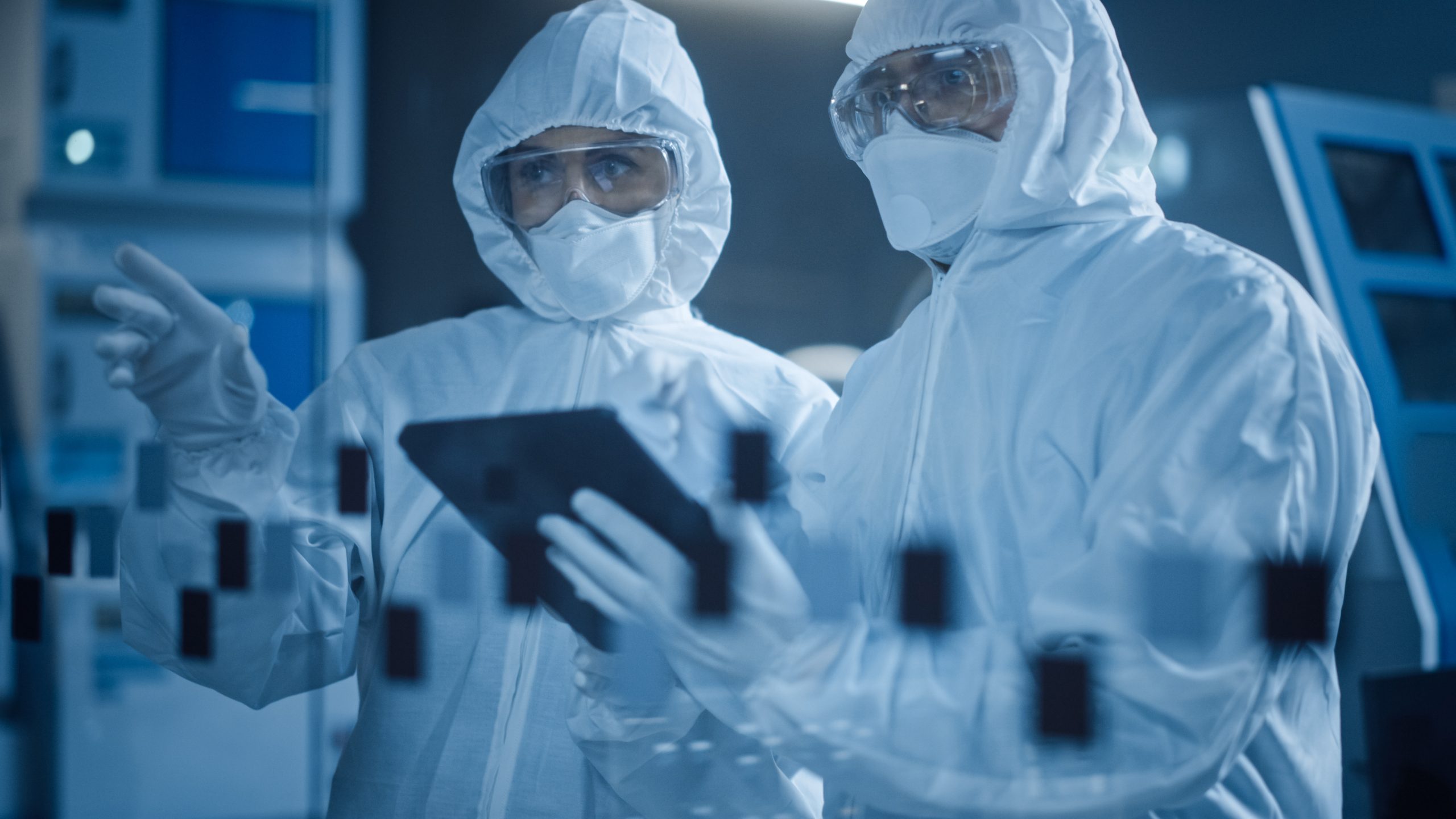 Factory Cleanroom: Engineer and Scientist Wearing Coveralls, Standing in Workshop Talk and Use Tablet Computer, Professionals Develop Technology for Modern CNC Machinery and Electronic Equipment