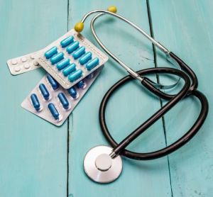 concept of clinical trials - stethoscope and pill packets on a wooden board background