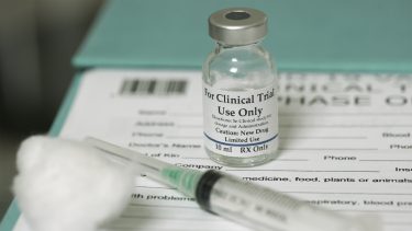 Vial of drug labelled 'FOR CLINICAL TRIAL USE ONLY' next to syringe and data form