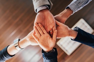 Bottom view of people hands holding together - idea of a consortium or collaboration