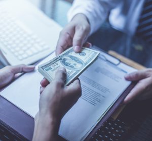 businessmen exchanging contract and money (US Dollars)