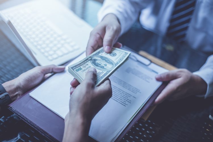 businessmen exchanging contract and money (US Dollars)