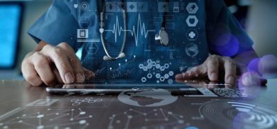 Medical professional using tablet overlaid with data interface
