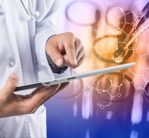 laboratory scientist in white coat holding a tablet with laboratory experiment running in background