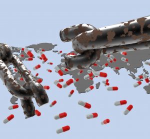 chain with a broken link in front of a world map with medicine capsules on it