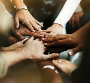 Closeup of diverse people joining their hands - idea of ending racism and encouraging diversity, equality and inclusion