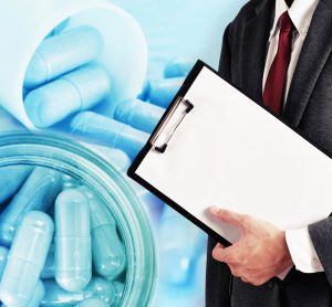 man holding a clipboard in a suit overlaid on a close up of blue pills in a tube - idea of drug evaluation/approvals