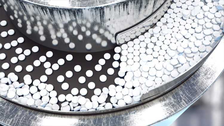 flat white circular pills on a production line