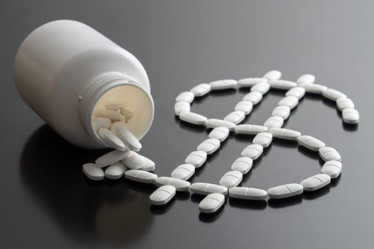 medicine bottle spilling white pills in the shape of a dollar sign - idea of pharma finances or drug pricing