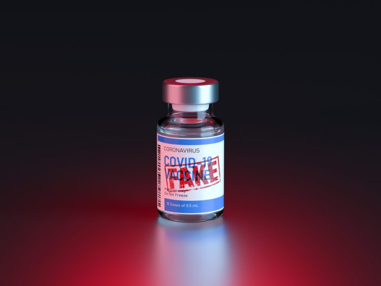 Vial labelled 'COVID-19 Vaccine' with red stamp proclaiming 'FAKE' over label - idea of counterfeit vaccines