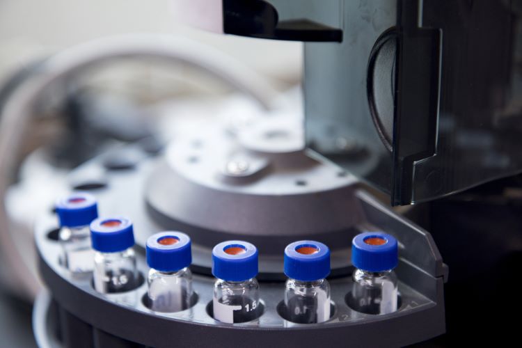 blue capped vials are arranged in the auto-sampler of gas chromatography equipment