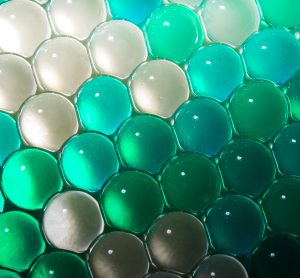 blue and green hydrogel balls in rows