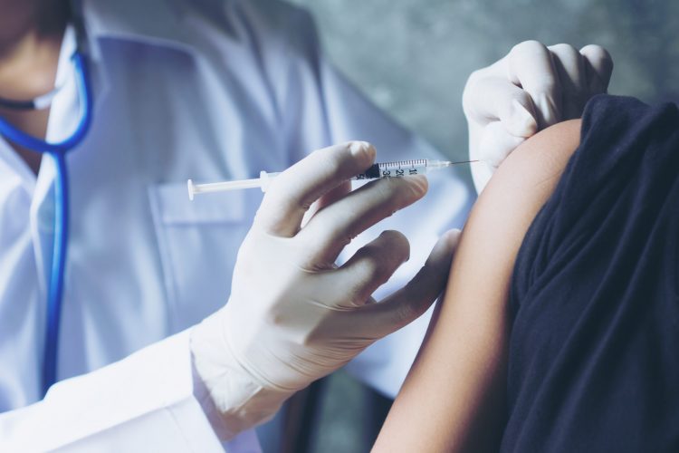 doctor injecting patient using syringe