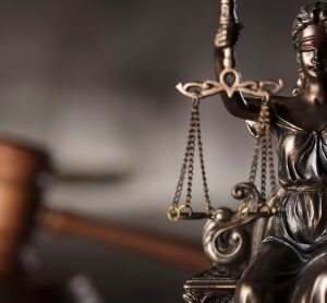 Lady Justice holding scales with gavel in the background