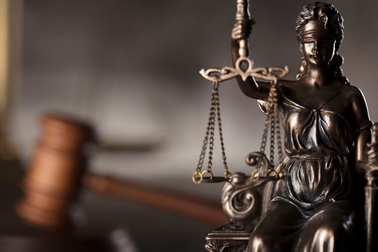 Lady Justice holding scales with gavel in the background