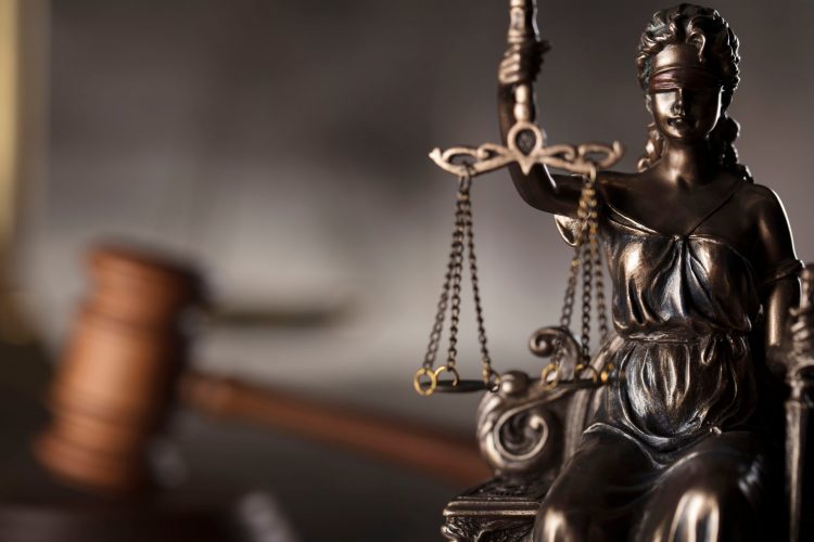 Lady Justice holding scales with gavel in the background