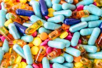 various colourful capsules in a pile filling the whole image - idea of supply of medicines