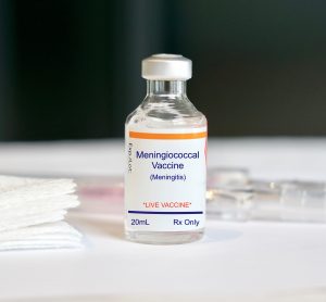 vial labelled 'Meningococcal vaccine' next to syringe and gauze pads