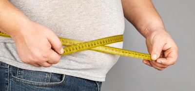 Man with tape measure depicting obesity
