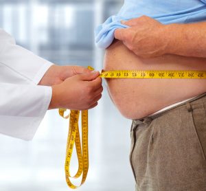 Doctor measuring the stomach of an overweight man