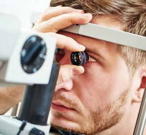 man undergoing an eye examination by an ophthalmologist