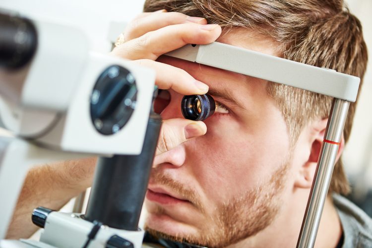 man undergoing an eye examination by an ophthalmologist