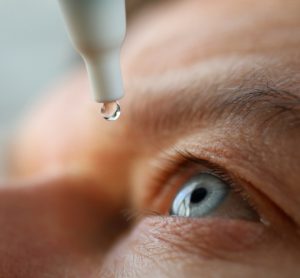 close up of man using eye drops