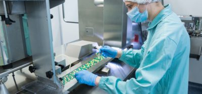 Technician checking solid oral pills in manufacturing facility