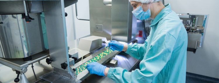 Technician checking solid oral pills in manufacturing facility