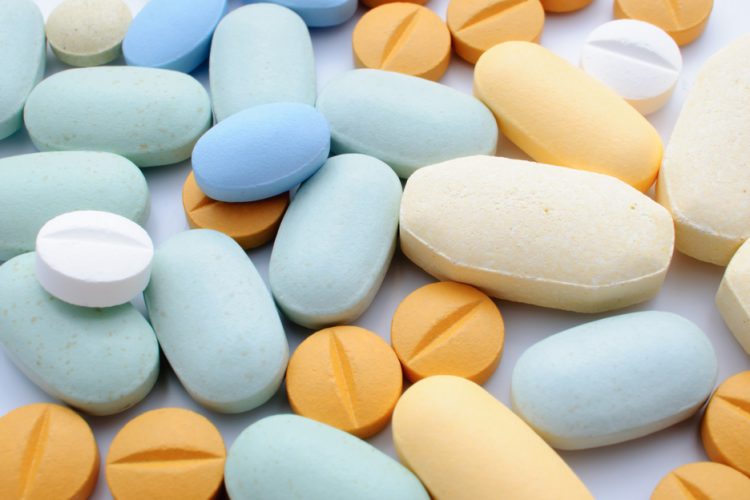 Pile of colourful pharmaceutical tablets in orange and blue