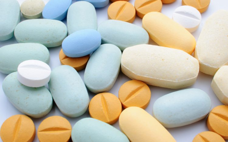 Pile of colourful pharmaceutical tablets in orange and blue