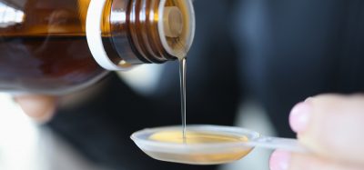 close up of an oral solution being poured onto a medicine spoon