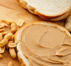 peanuts, peanut butter on bread and monkey nuts laid out as examples of peanut allergens