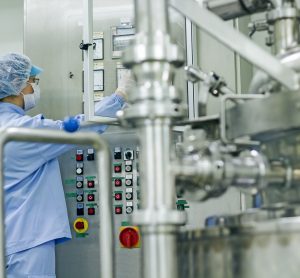 pharmaceutical factory worker operating machine