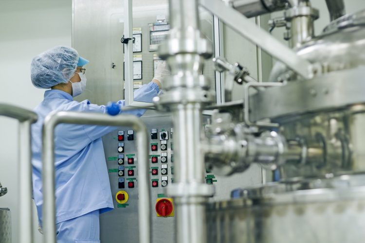 pharmaceutical factory worker operating machine