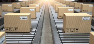 Cardboard boxes on conveyor belts heading out into the distance - idea of pharma supply chains