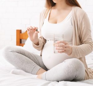 pregnant woman taking a tablet