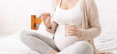 pregnant woman taking a tablet