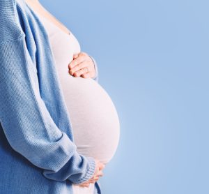 Woman holding pregnant stomach