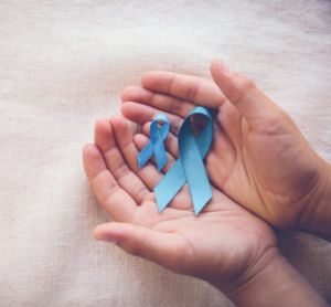 cupped male hands holding two looped blue ribbons - the symbol of prostate cancer