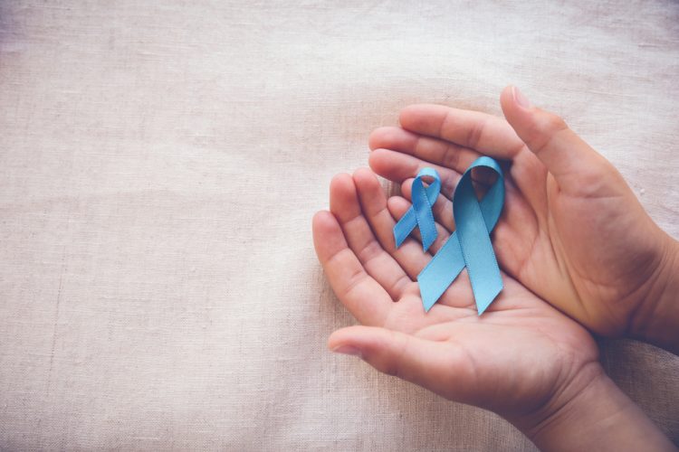cupped male hands holding two looped blue ribbons - the symbol of prostate cancer