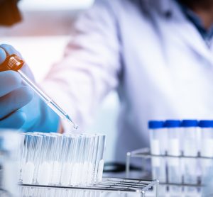 scientist pipetting liquid into a test tube