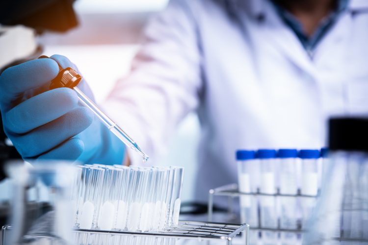 scientist pipetting liquid into a test tube