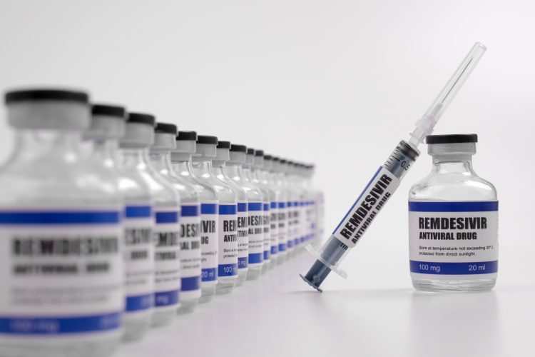 vials lined up labelled 'remdesivir' with one pulled out with a syringe balanced on it labelled the same
