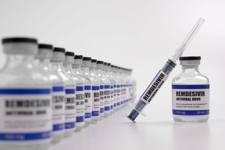 vials lined up labelled 'remdesivir' with one pulled out with a syringe balanced on it labelled the same