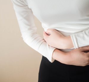 Young woman clenching stomach in pain