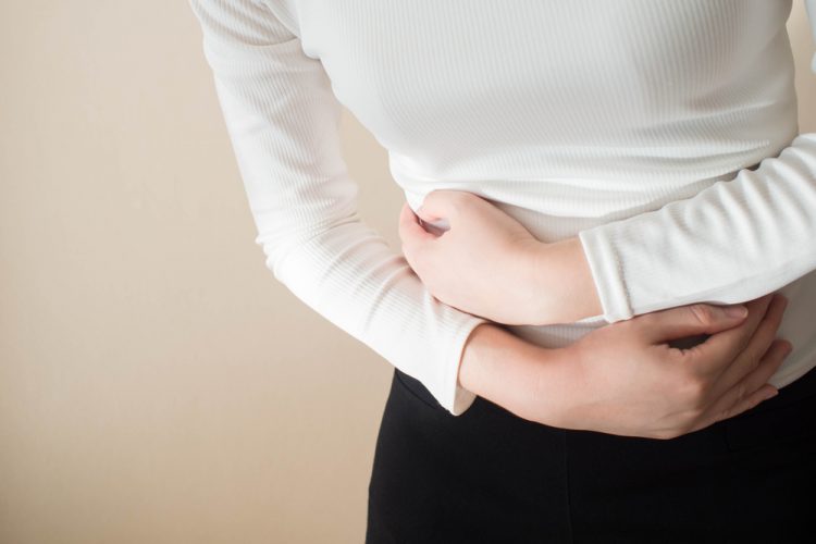 Young woman clenching stomach in pain