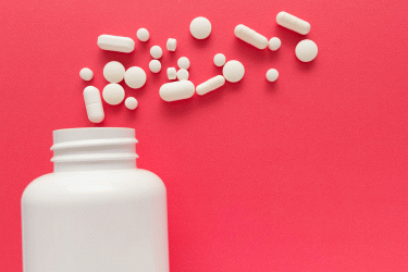 White pills on red background