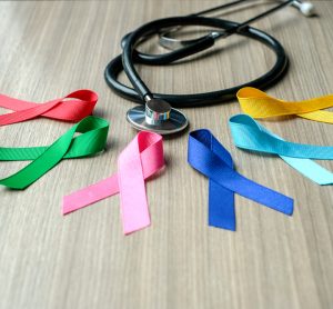 Different colour cancer ribbons next to stethoscope